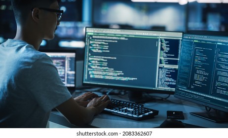 Night Office: Young Handsome Man in Working on Desktop Computer. Digital Entrepreneur Typing Code, Developing Modern Software, e-Commerce App Design, Developing of e-Business. Over Shoulder