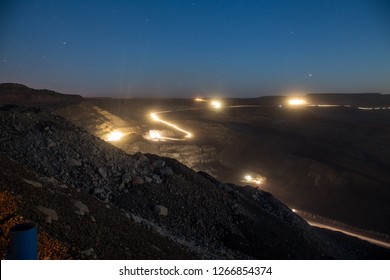 
Night Over The Coal Cut. Mine Under The Stars. View From Above. Starry Sky And Heavy Machinery. Work At Night. Big Cars. Beautiful Night Landscape Open Cut.