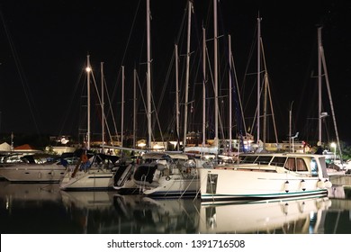 Night parking of yachts in the Croatian ACI marina of the town of Jazira. Burning lights of the evening Mediterranean port with sailing yachts and fishing boats. Twilight on the Adriatic Riviera. Calm
