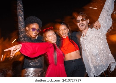 Night photo with flash and motion of multi-ethnic friends having fun during city night - Powered by Shutterstock