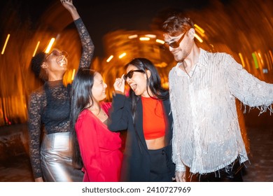 Night photo with flash and motion of multiracial friends dancing together in the city street - Powered by Shutterstock