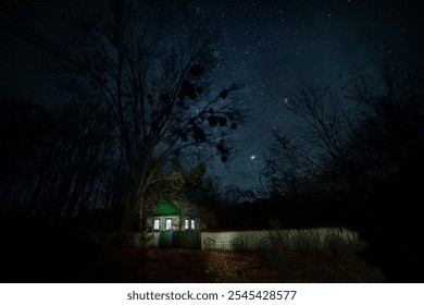 Night photo. Old wooden small rural house under the starry sky. - Powered by Shutterstock