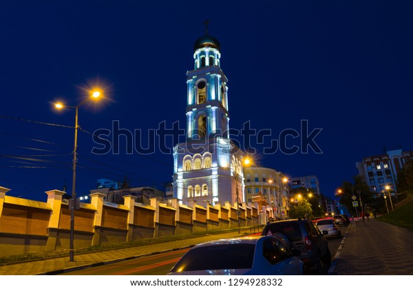 The night picture of brightly lit church\
and the monastery against the background of the blue night sky and\
brightly lit road with the passing\
cars.