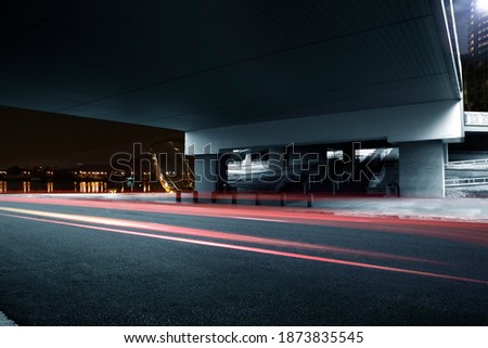 night road under bridge with light trail 