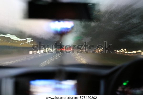 Night road view from inside car natural light\
street and other cars is motion blurred, Blur image from inside a\
car traveling at night\
time.