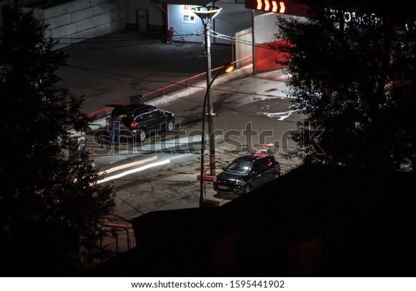 Night round the clock car wash.\
Car drivers wash nd repair their auto taking rest after long\
way.People unrecognizable blurry as they move. Above aerial\
view
