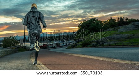 Night runner, caucasian male in city park at sunset