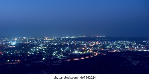 Night Scape Of City With Lights And Vehicle Strikes And Blue Sky