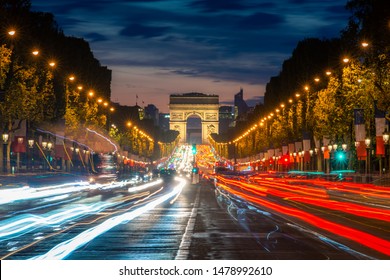 Night Scence Illuminations Traffic Street Of The Impressive Arc De Triomphe Paris Along The Famous Tree Lined Avenue Des Champs-Elysees In Paris, France.