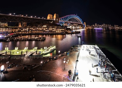 The Night scene of individuals strolling on a pier in Sydney during the light festival - Powered by Shutterstock
