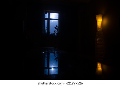 Night Scene Of Moon Seen Through The Window From Dark Room. Moonlight Inside Dark Room