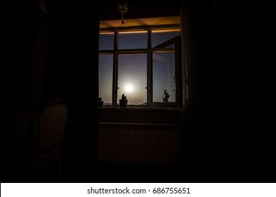 Night scene of moon seen through the window from dark room. Moonlight inside dark room