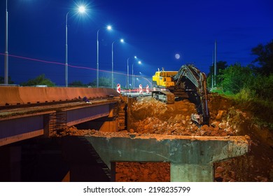 Night Scene With Standing Hydraulic Excavator At Bridge Demolition Site.