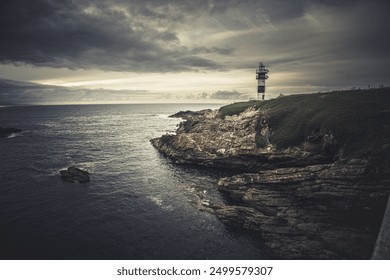 Night seascape with lighthouse in the dark night stormy nines. sunset background lighthouse Isla Pancha Ribadeo Galicia Spain. iconic old lighthouse on rocky island, coastal landscape with cliffs - Powered by Shutterstock