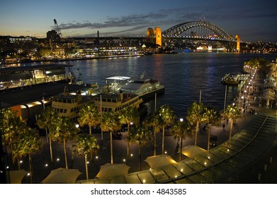 Night Shot Of Circular Quay In Sydney; Harbour Bridge In Background