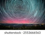 The night sky above Serra Del Montsec, Lleida, Spain. October 2024 is painted with vibrant star trails and northern lights creating a mesmerizing celestial display