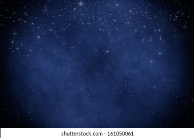 Night Sky Background Texture Of Twinkling White Stars, Sprinkled On Deep Blue Parchment Paper With Vignette.