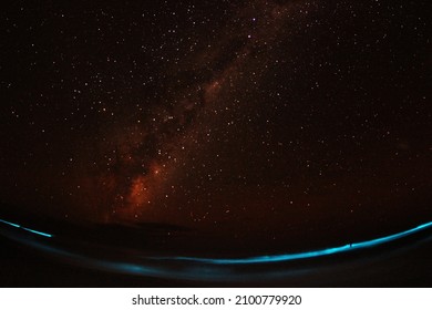 Night Sky With Bioluminescent Algae In The Water