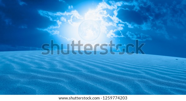 Night sky with blue moon\
in the clouds with desert (sand dune)\