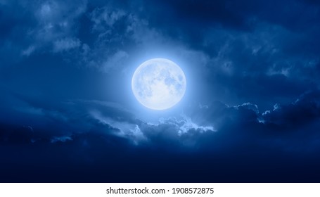Night sky with full bright moon in the clouds 