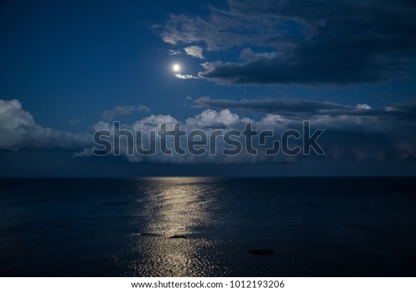 Night sky with\
full moon and reflection in\
sea.