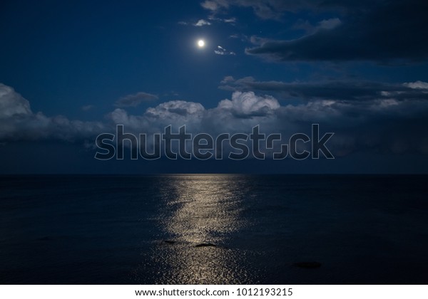 Night sky with full moon and reflection in sea,\
beautiful clouds.