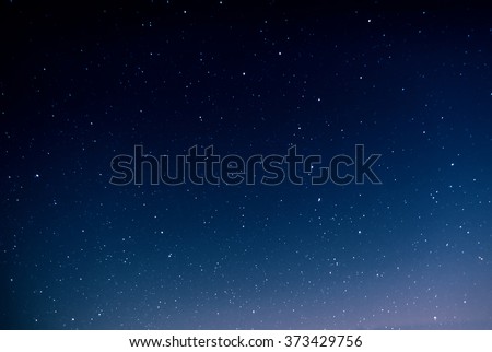 Night sky full of stars and sunrise on the background horizon. Beautiful view from the top of the mountain.