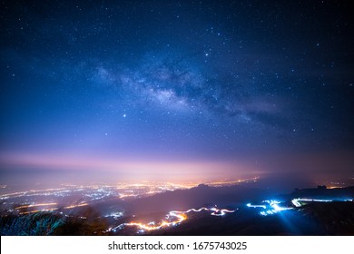 Night Sky With Milky Way And Stars. Night Road Illuminated By Car. Light Trails