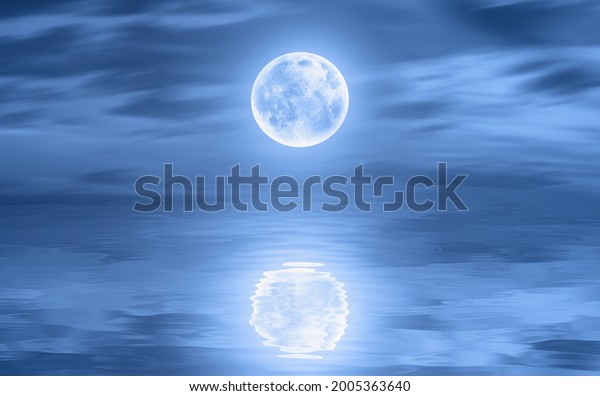 Night sky with moon in the\
clouds on the foreground calm sea\