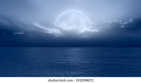 Night Sky With Moon In The Dark Clouds And Darkblue Sea In The Foreground 