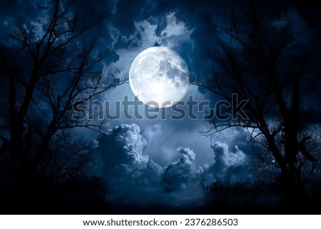 Night sky with moon light. Dramatic clouds in mystic moonlight. Large bright moon as concept of mystery, midnight, gothic time and spooky theme. Moody sky texture background.