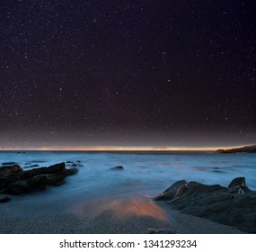 Night sky from a rocky beach. Cornwall, UK.
