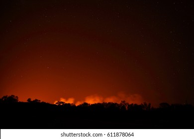 The Night Sky With Stars Over The West Macdonnell Ranges Near Alice Springs With The Red Glow Of A Bushfire.