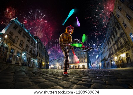 Night street circus performance whit clown, juggler. Festival city background. fireworks and Celebration atmosphere.