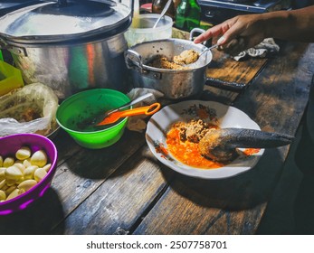 Night street food vendor preparing Ketoprak, an Indonesian vegetarian spicy dish from Jakarta, consisting of fresh garlic, chili, tofu, vegetables, rice cake and rice vermicelli served in peanut sauce - Powered by Shutterstock