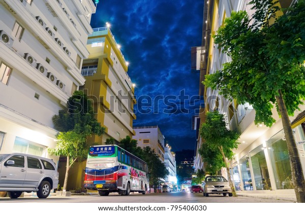 Night street, Phuket. Tourist bus and cars\
near hotels in the spa town, Phuket, Thailand. Beautiful night sky\
moonlight in space above\
buildings.