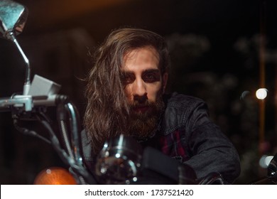 Night Street Portrait Of Young Guy With Long Hair On A Black Motorcycle