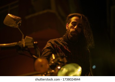 Night Street Portrait Of Young Guy With Long Hair On A Black Motorcycle