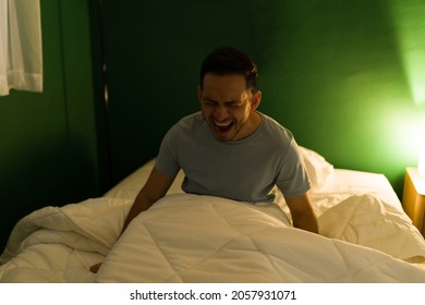 Night Terrors. Afraid Young Man Waking Up In The Middle Of The Night Form A Scary Nightmare And Screaming In Bed