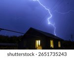Night thunderstorm with lightning and thunder over the village in summer