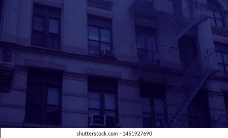 Night Time Exterior Establishing Shot Outside A Typical Generic Urban City Style Apartment Building. Blue Moon Light Effect. Setting For College Dorm Loft Flat Rented Home