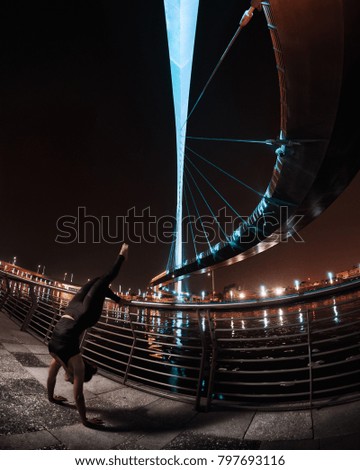 Night Time Outdoor Portrait of young female middle eastern yogi doing a handstand bu a bridge