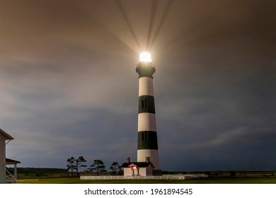 Night time photo of Bodie Island Lighthouse shining its beacon on the North Carolina Outer Banks
