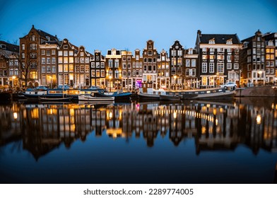 Night time shot of the Singel canal, Amsterdam with historic buildings along the bank - Powered by Shutterstock