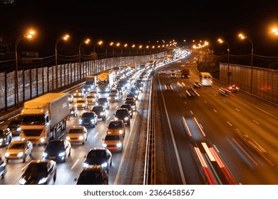 Night time shot of a traffic jam on a main road in Moscow; night view of gridlocked vehicles on a busy highway in Russia; photo of evening rush hour in Moscow with streetlights and two way traffic
 - Powered by Shutterstock