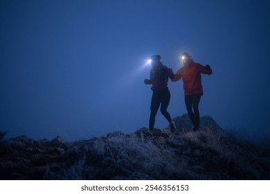 Night trail runner of men and women running on the mountain.at night milky way - Powered by Shutterstock