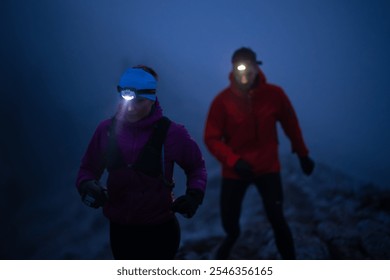 Night trail runner of men and women running on the mountain.at night milky way - Powered by Shutterstock