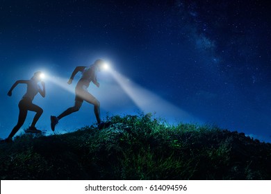 Night Trail Runner Of Men And Women Running On The Mountain.at Night Milky Way