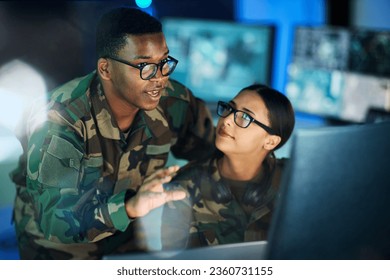 Night training, army and people with a computer for communication, planning strategy or surveillance. Cyber security, data center and a black man talking to a woman about monitor in a military room - Powered by Shutterstock