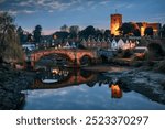 Night view to Aylesford village in Kent, England with medieval bridge and church.